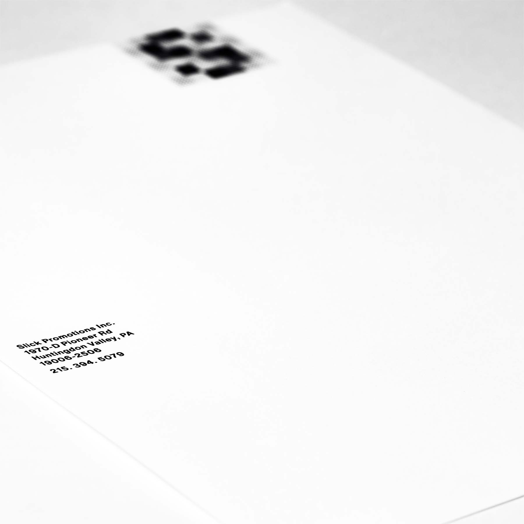 Slick Promotions letterhead with address in focus and logo in background.